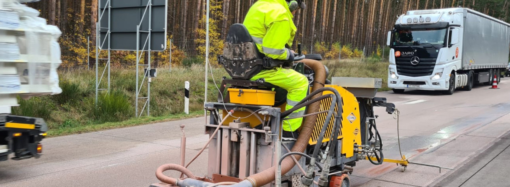 Cedima Fugenschneider CF 6022 im Einsatz auf Strasse. Mit Bauarbeiter, der die Maschine steuert.