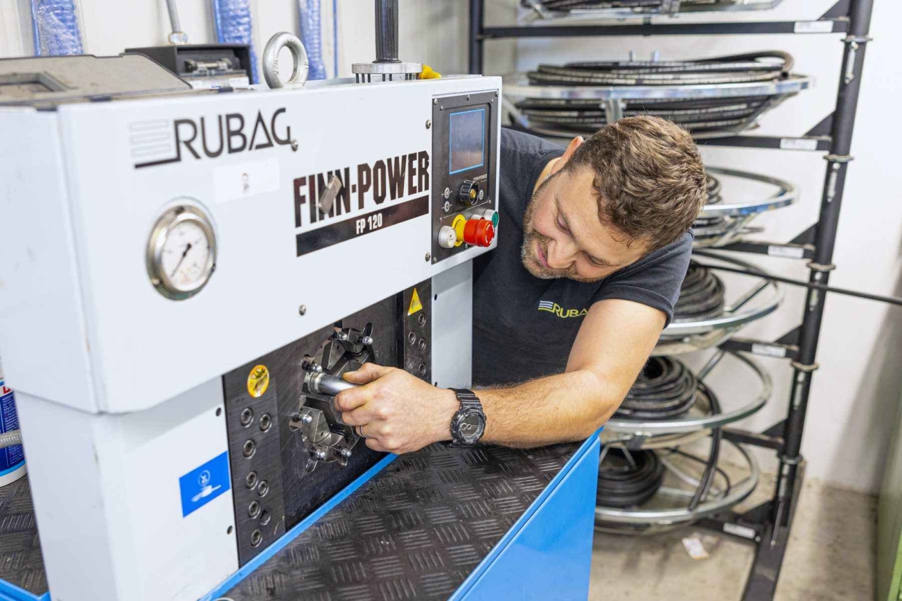 RUBAG Mitarbeiter konfektioniert neuen Hydraulikschlauch